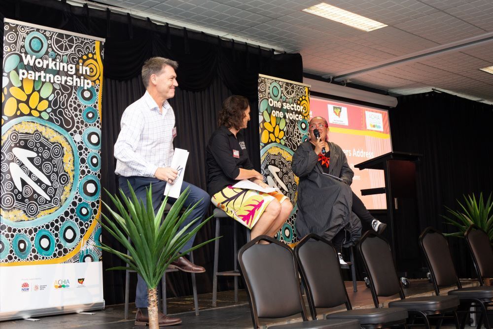 Man and two women sitting on stage